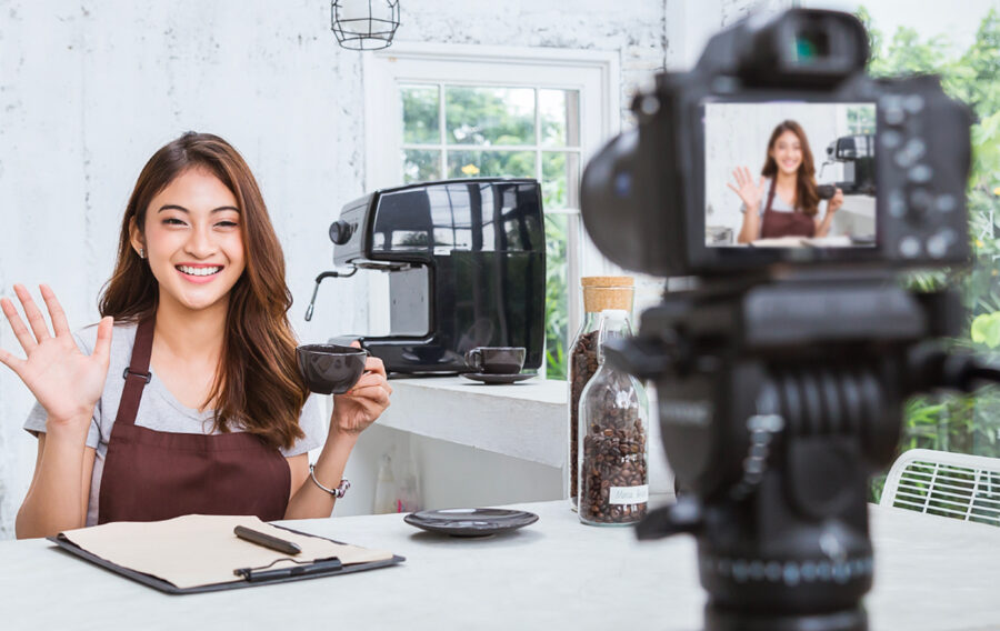 person being filmed, smiling and waving at the camera humanize your brand on social media