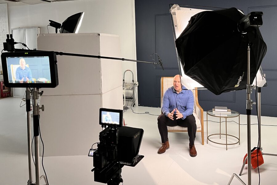 Using Video Marketing to Strengthen Your Business in 2026, A picture of someone sitting on a chair being filmed in a a studio